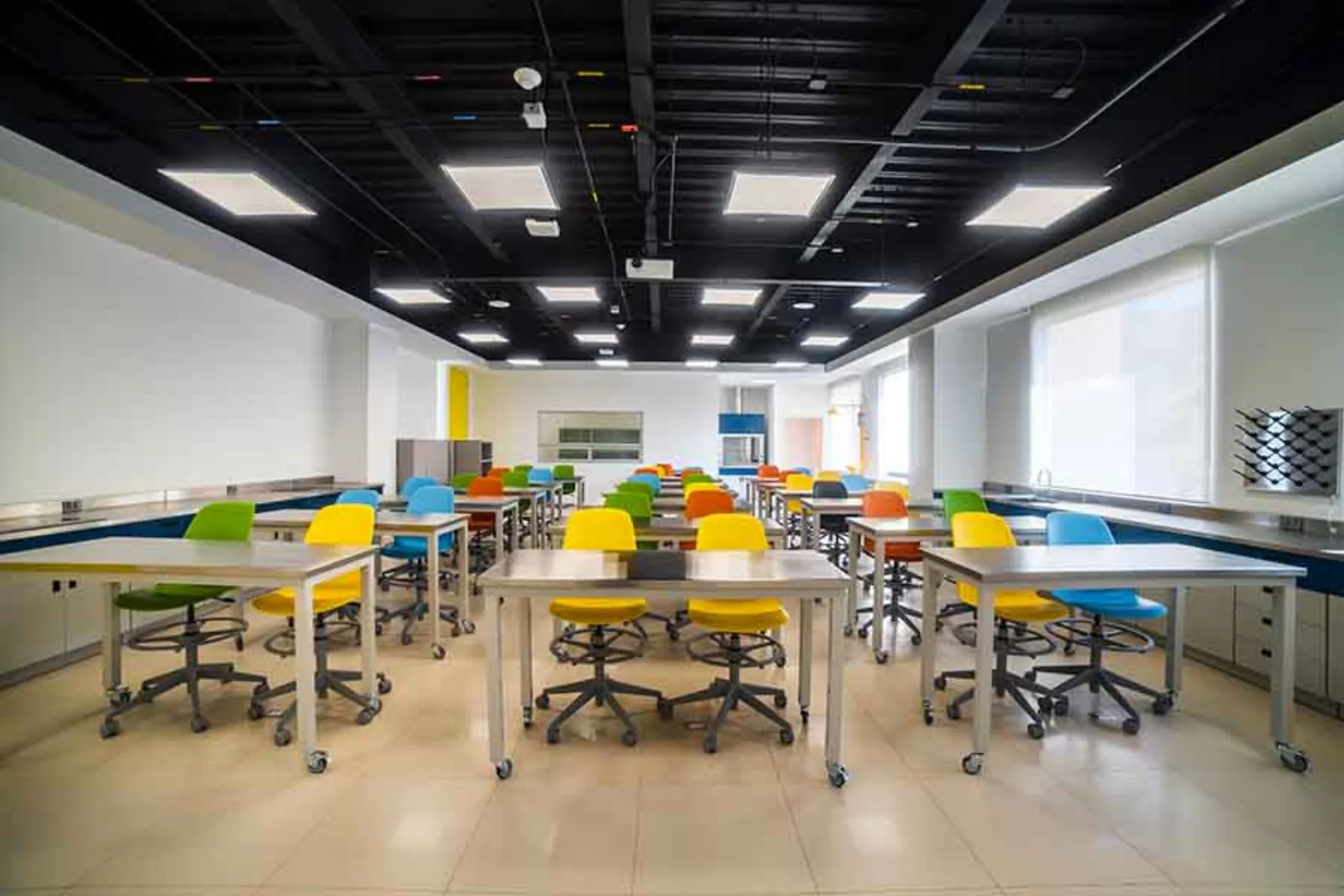 Salón de clases del Tec de Monterrey, con mesas de trabajo y bancos de colores dispuestos para trabajo en equipo